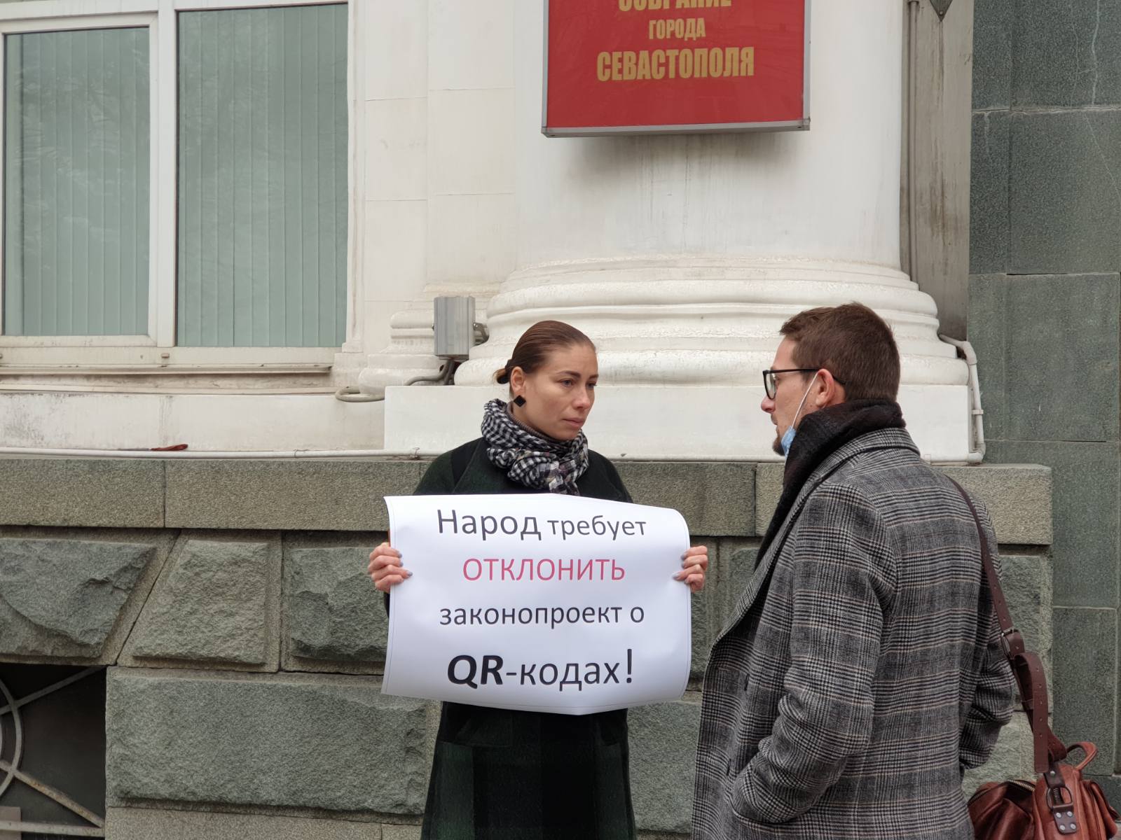 Депутат Заксобрания Антон Пархоменко разговаривает участницей пикета против законопроекта о QR-кодах