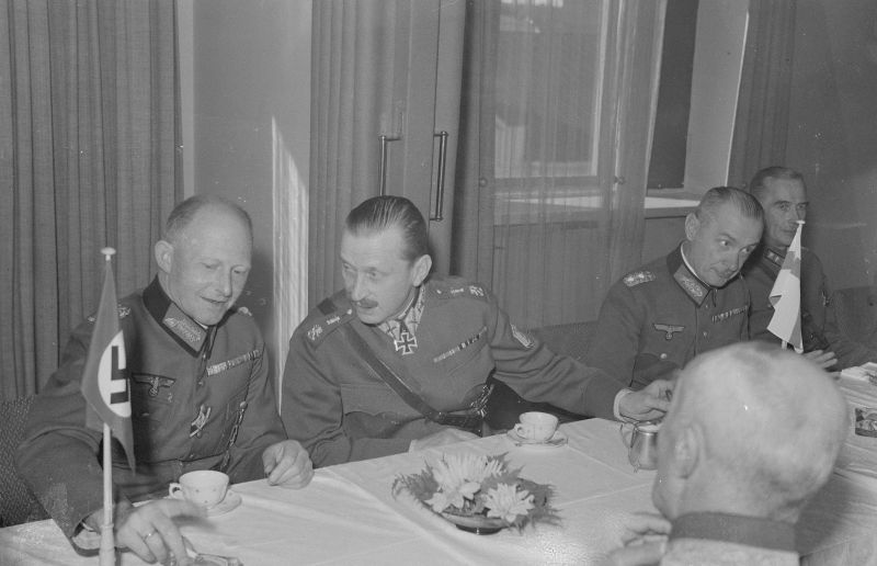 Начальник оперативного отдела Верховного главнокомандования Вермахта (ОКВ) генерал артиллерии Альфред Йодль (Alfred Josef Ferdinand Jodl, 1890-1946, слева) и финский маршал Карл Густав Эмиль Маннергейм (Carl Gustaf Emil Mannerheim, 1867—1951) за столом во время встречи в Миккели (Mikkeli). Второй справа — немецкий представитель при Генеральном штабе финской армии генерал пехоты Вальдемар Эрфурт (Waldemar Erfurth, 1879—1971).