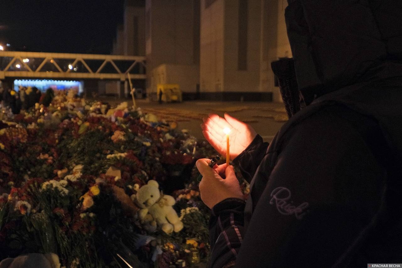 Человек со свечой у мемориала жертвам теракта