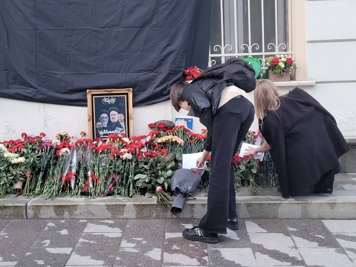 Девушки размещают памятные послания у мемориала