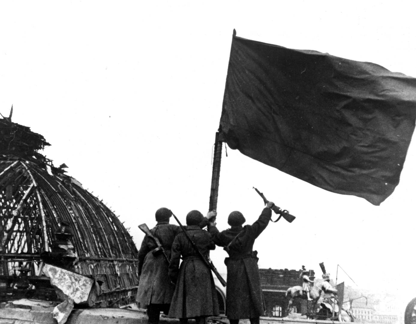 Советские бойцы и знамя, водруженное над Рейхстагом. Май. 1945